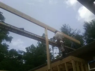 Carpenter setting a ridge beam over a new addition frame — Ice Dam Removal by Roofing Brothers in Prairie Lea