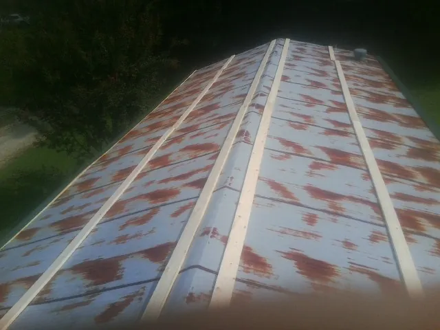 Rusted metal roof panels with new wood purlins before replacement — Storm Damage Roof Repair in Prairie Lea by Roofing Brothers